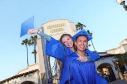 Two graduates celebrating in front of Universal Studious 